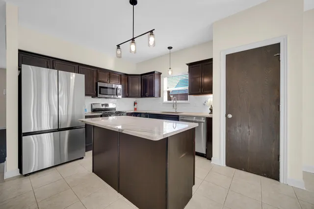 a kitchen with kitchen island a counter top space stainless steel appliances and cabinets