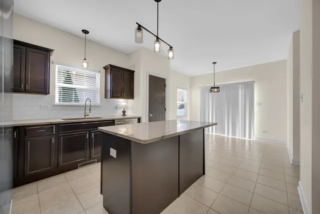 a kitchen with a sink a counter top space appliances and cabinets