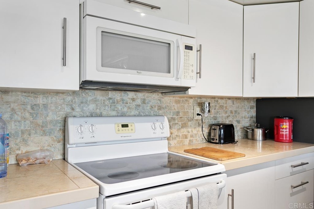 3606 Vista Rey Oceanside, CA 92057 - Photo 23 of 40 a kitchen with stainless steel appliances granite countertop a sink a stove and white cabinets