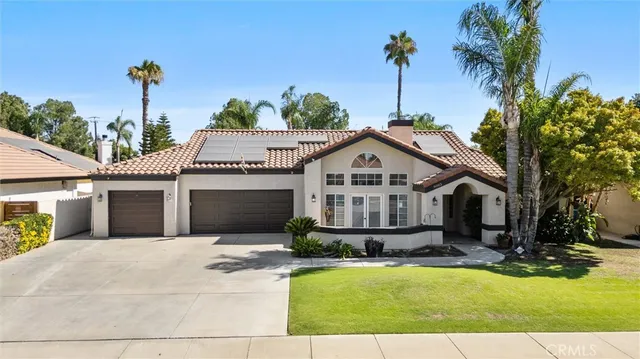 a front view of a house with a yard and potted plants