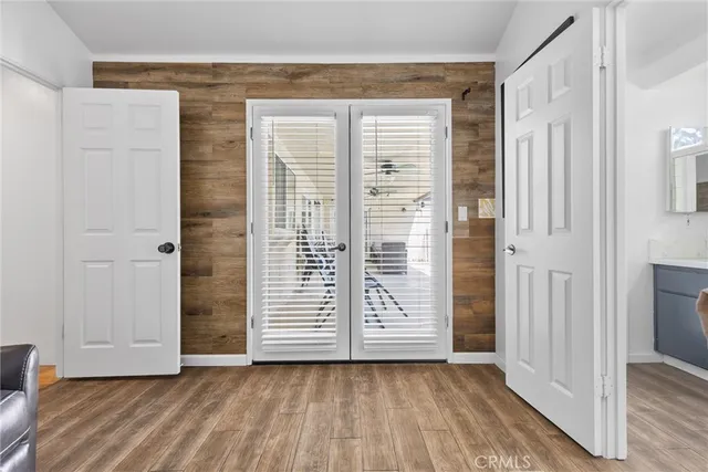 an empty room with wooden floor closet and windows