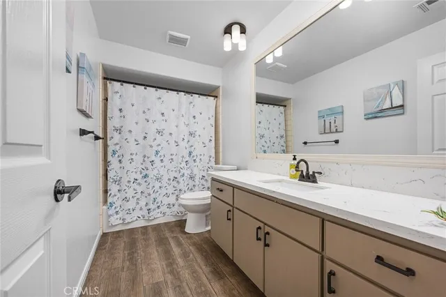 a bathroom with a sink a toilet a shower curtain and a mirror