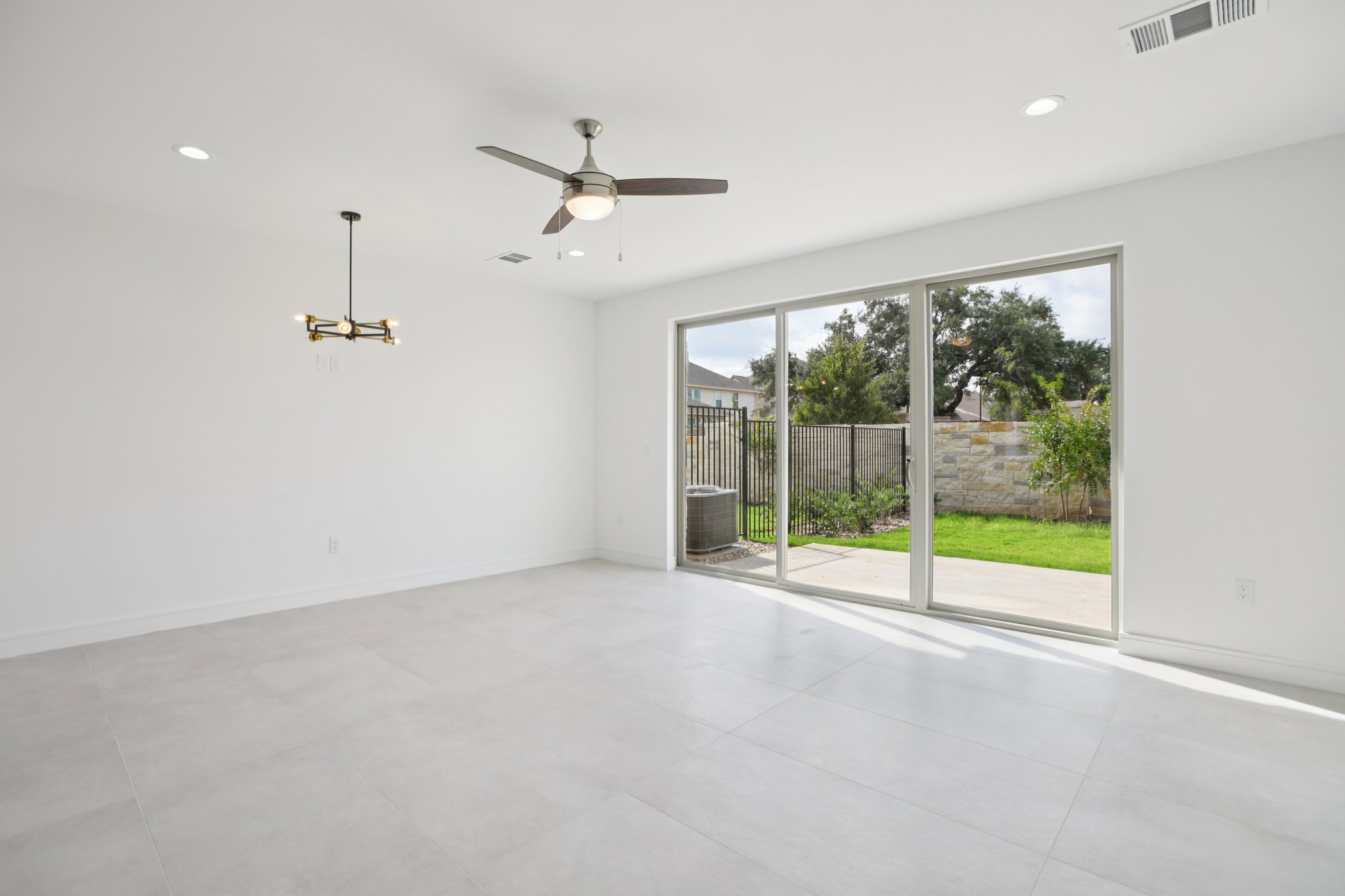 202 Tesla Circle Austin, TX 78681 - Photo 7 of 35 Unfurnished room with ceiling fan and hanging lights