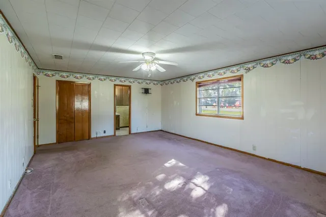 an empty room with windows and fireplace