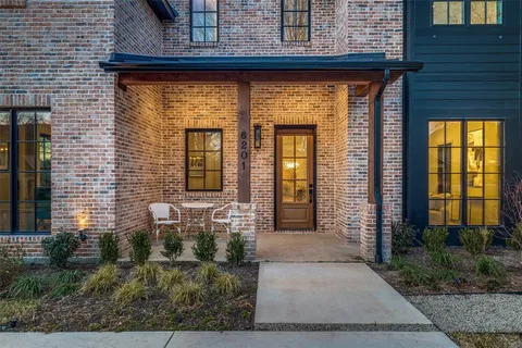 a living room with couches a fireplace and a chandelier