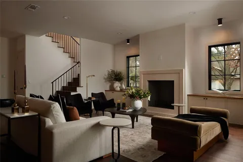 a kitchen with stainless steel appliances a dining table chairs sink and wooden floor
