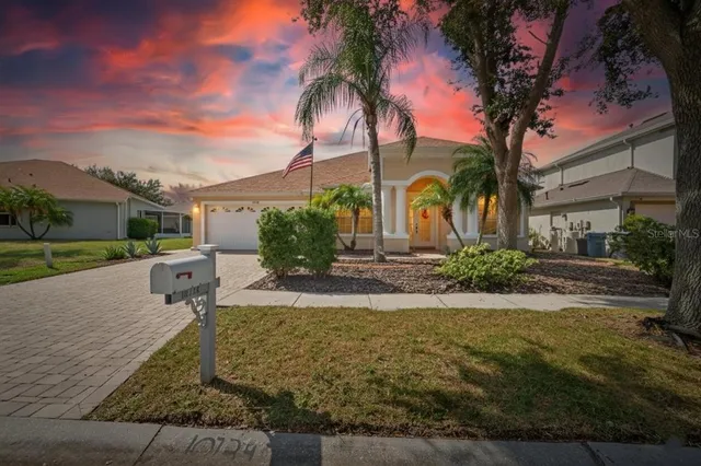 a front view of a house with garden and trees