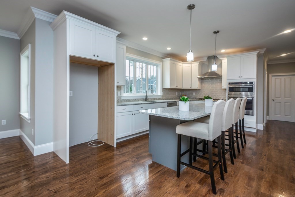 38 F Hiley Brook Road Stow, MA 01775 - Photo 7 of 26 a kitchen with kitchen island granite countertop wooden floor cabinets dining table and chairs