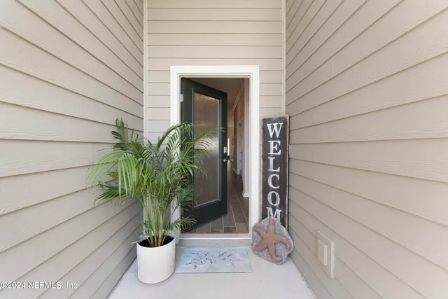 a view of a hallway with wooden floor and a bathroom