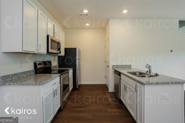 115 Dudley Way Southwest Cartersville, GA 30120 - Photo 8 of 16 a kitchen with stainless steel appliances granite countertop a stove a sink and a refrigerator