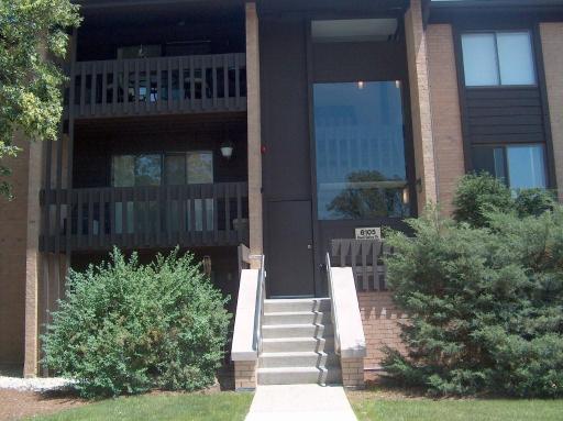 a view of a house with a small yard and wooden fence