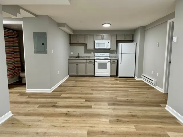 a kitchen with white cabinets and white appliances