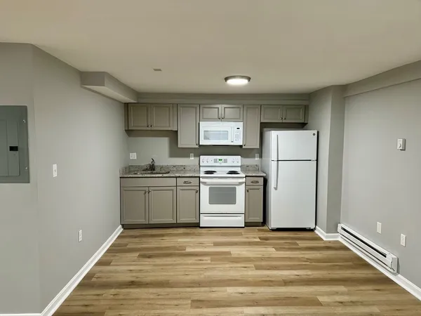 a kitchen with a refrigerator and white cabinets