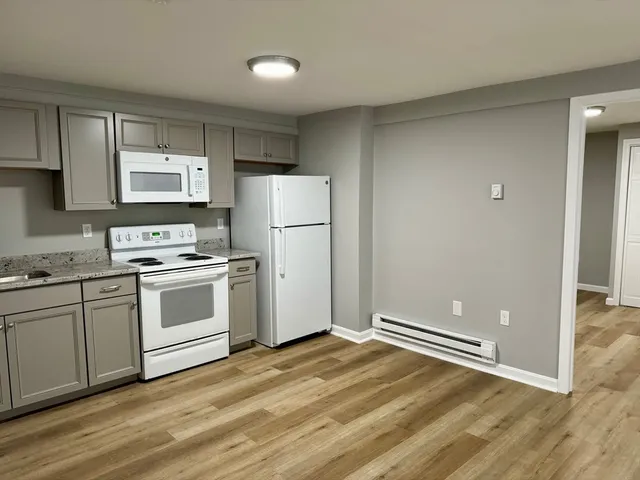 a kitchen with white cabinets and white appliances