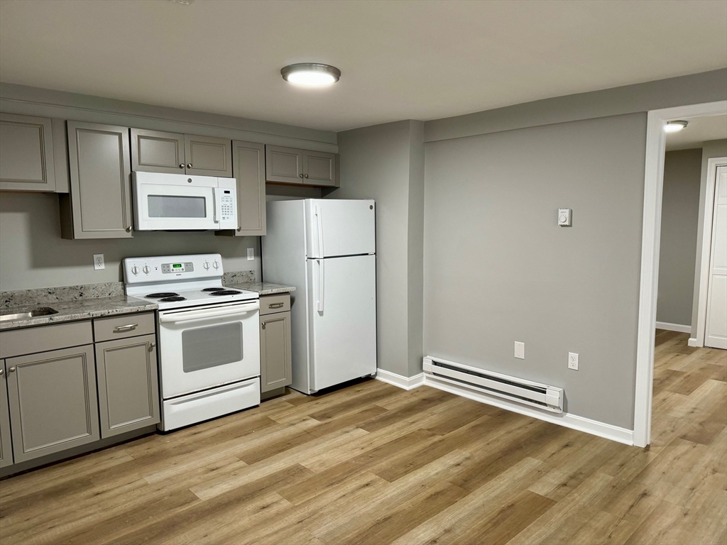 38 Emmons Street, Unit 5 Franklin, MA 02038 - Photo 3 of 16 a kitchen with white cabinets and white appliances