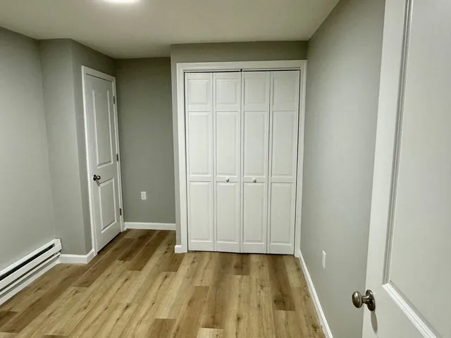 an empty room with wooden floor and closet