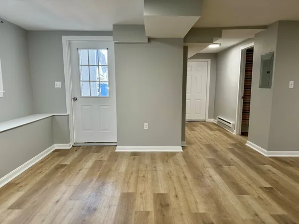 a view of an empty room with window and wooden floor
