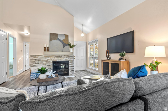 888 East 6895 South Midvale, UT 84047 - Photo 5 of 54 Cozy living space featuring a stone-accented fireplace as the focal point, complemented by modern flooring and a functional layout.