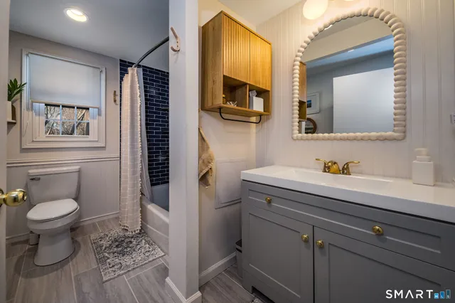 a bathroom with a sink a toilet and mirror