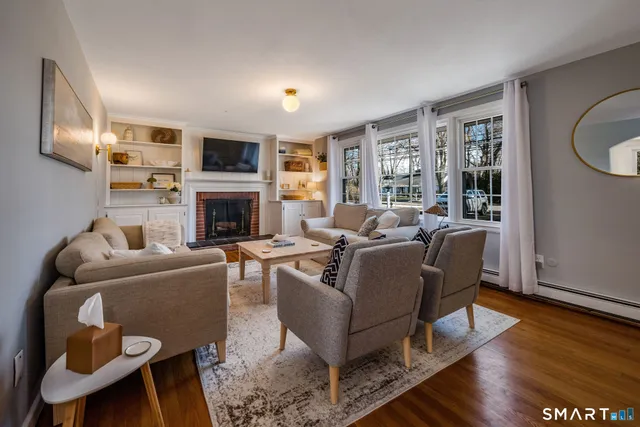 a living room with furniture a fireplace and a window