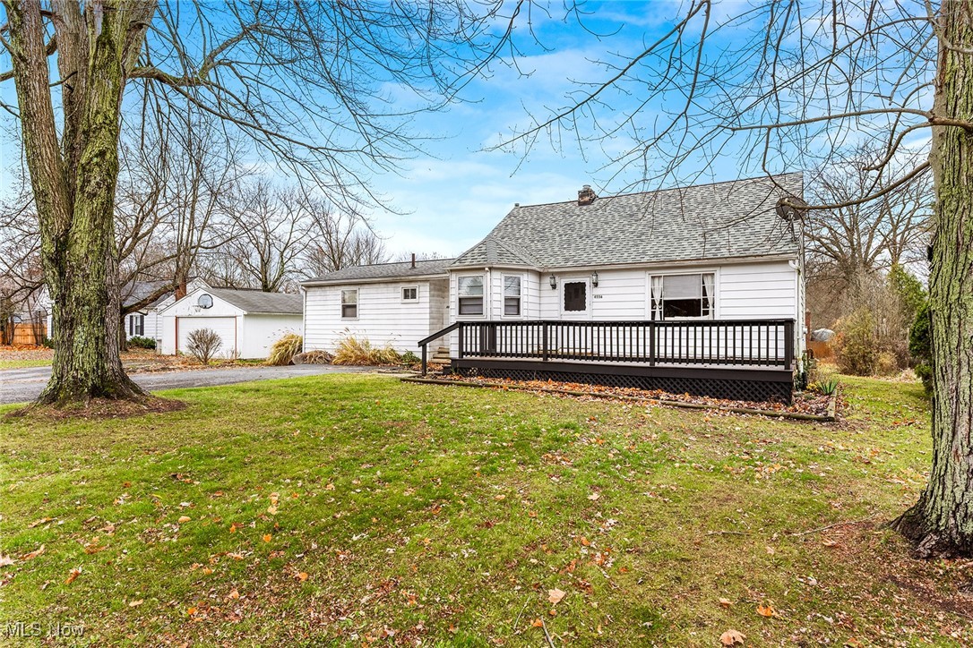 4556 Fishcreek Road Stow, OH 44224 - Photo 2 of 41 Rear view of property with a lawn, a wooden deck, an outbuilding, a chimney, and a garage