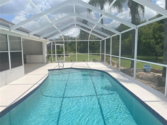 a view of a swimming pool with a bench in wooden floor