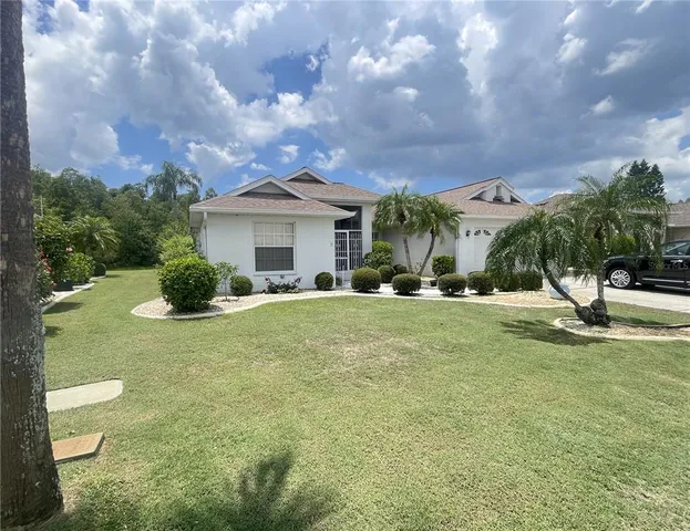 a view of an house with backyard and trees