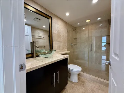 a bathroom with a double vanity sink toilet mirror and shower