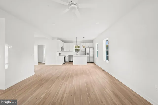 a view of empty room with wooden floor and window