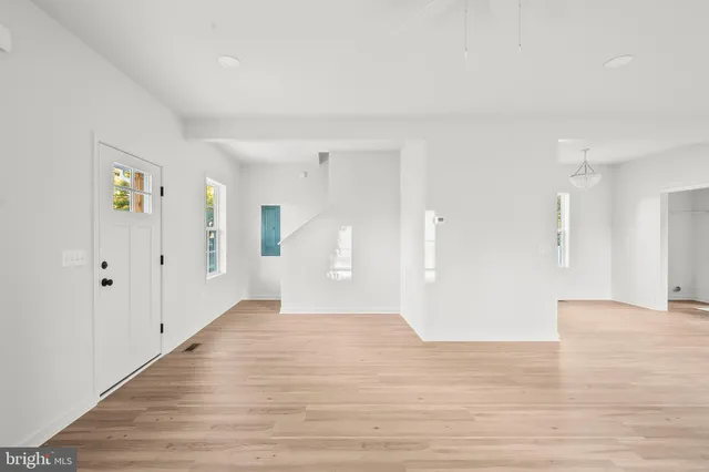 a view of a big room with wooden floor and windows