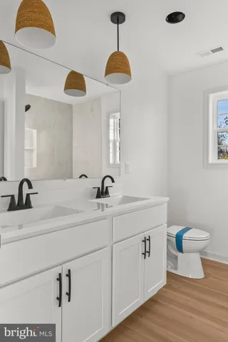 a bathroom with a toilet a sink and a mirror