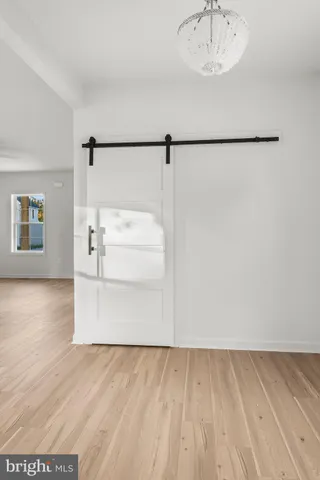 a view of a room with wooden floor cabinetry and a kitchen island