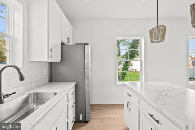 a kitchen with stainless steel appliances granite countertop a sink a stove and a refrigerator