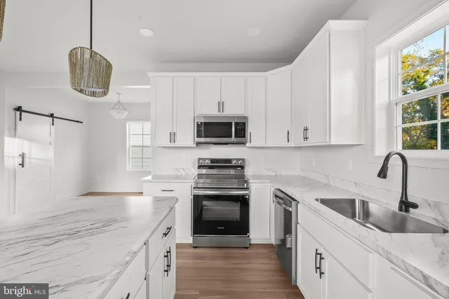 a kitchen with stainless steel appliances granite countertop a sink and a stove