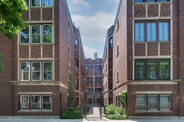 a view of a brick building plants and large windows