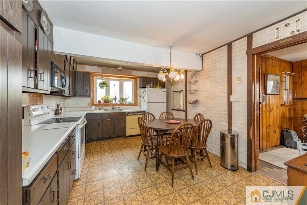 65 Ford Road Howell, NJ 07731 - Photo 10 of 22 a kitchen with a table chairs sink and cabinets
