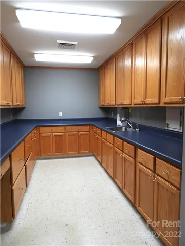 a view of a kitchen with granite countertop stainless steel appliances a sink window and cabinets