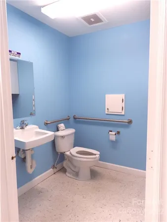 a bathroom with a toilet sink and mirror