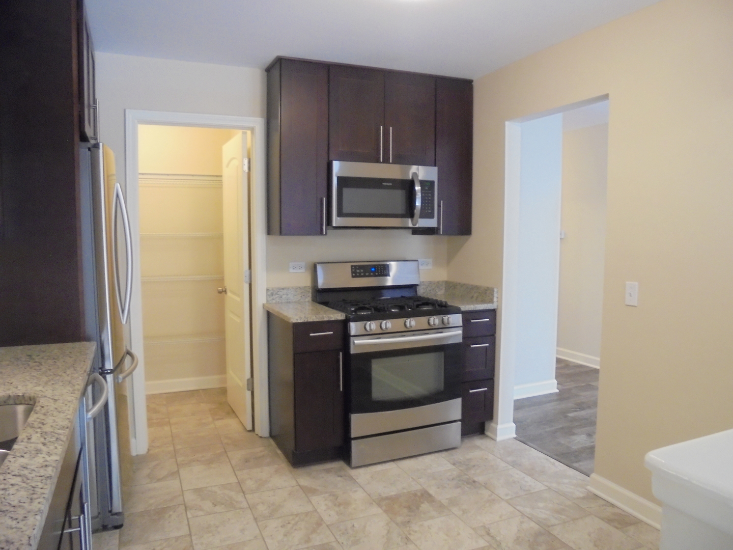 1534 Springview Court, Unit B2 Wheeling, IL 60090 - Photo 13 of 29 a kitchen with stainless steel appliances granite countertop a stove a microwave and a refrigerator