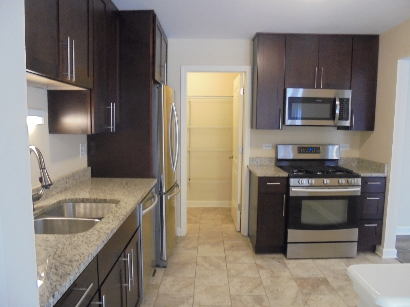1534 Springview Court, Unit B2 Wheeling, IL 60090 - Photo 14 of 29 a kitchen with stainless steel appliances granite countertop a sink stove and refrigerator