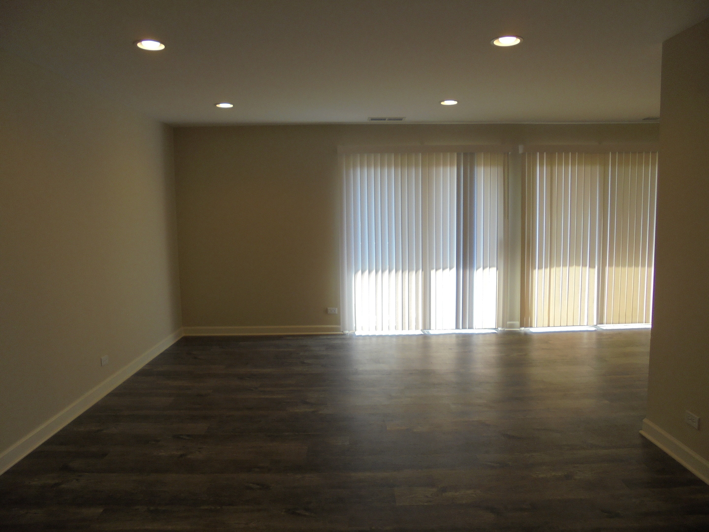 1534 Springview Court, Unit B2 Wheeling, IL 60090 - Photo 8 of 29 an empty room with wooden floor and windows with curtains