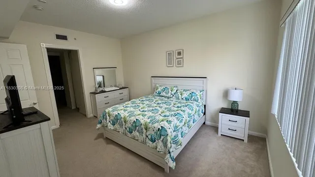 a bedroom with a bed and a tv on the dresser