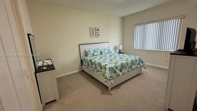 a bedroom with a bed and a flat tv screen on a dresser