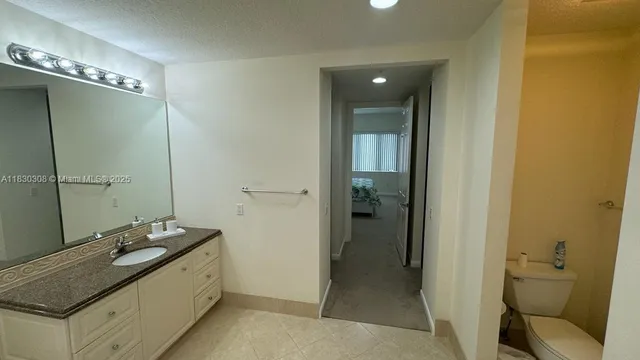 a bathroom with a sink and mirror with toilet
