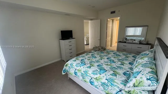 a bedroom with a bed and flat screen tv