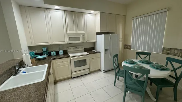 a kitchen with stainless steel appliances a stove a sink cabinets and a table