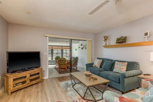 a living room with furniture a flat screen tv and a large window