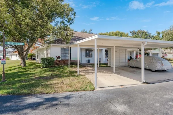 a view of a house with a patio and a yard