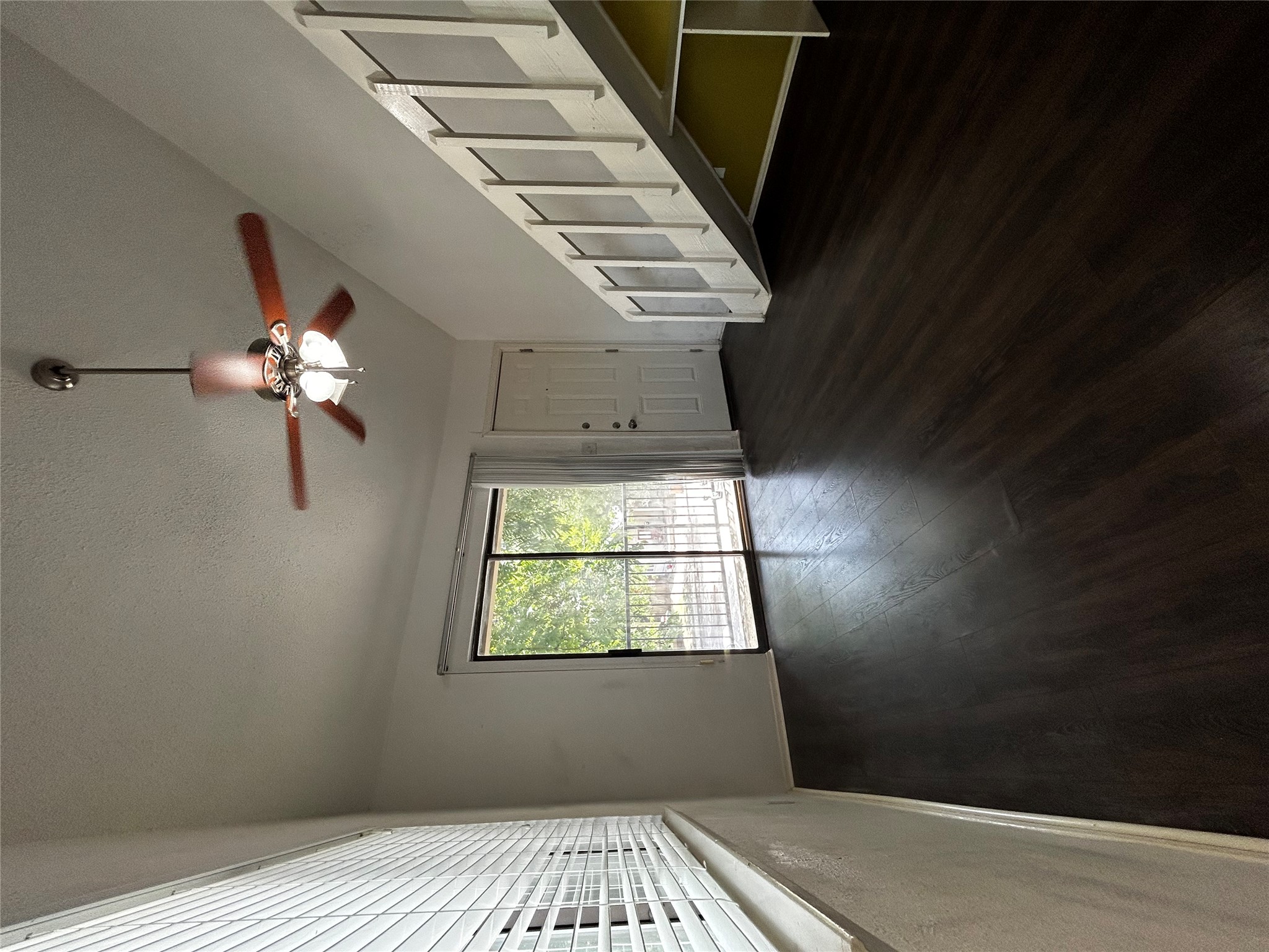 708 Graham Place, Unit 208 Austin, TX 78705 - Photo 3 of 9 Unfurnished living room featuring dark wood-type flooring, a textured ceiling, and a ceiling fan