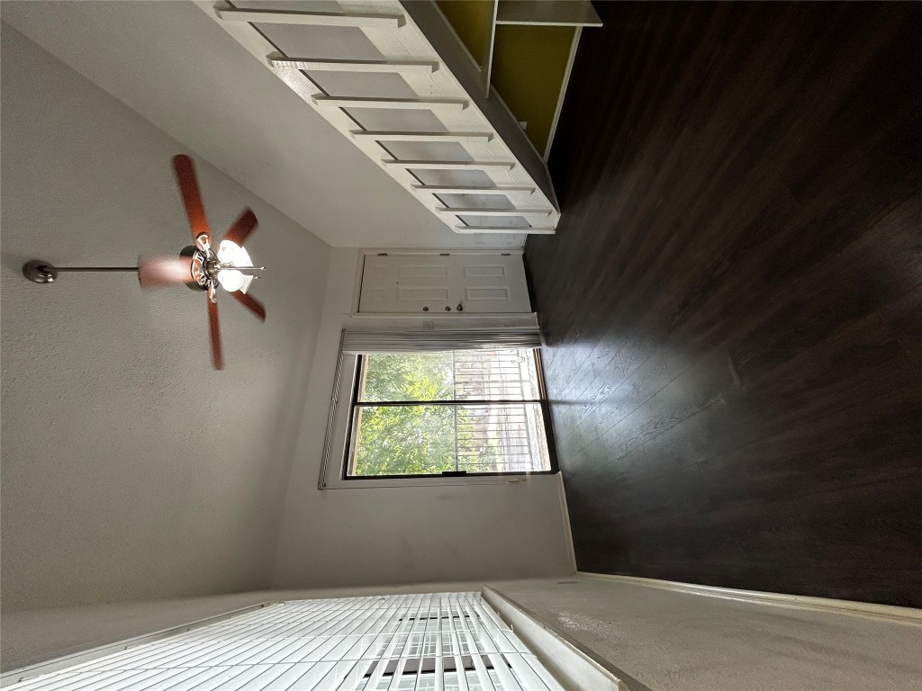 708 Graham Place, Unit 208 Austin, TX 78705 - Photo 3 of 9 a view of an empty room with wooden floor and a window